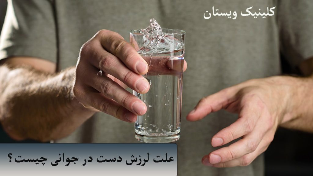 علت لرزش دست در جوانی دستهای یک فرد جوان که لیوانی آب در دست دارد و به علت لرزش دست آب در حال ریختن است